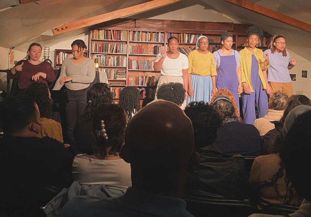 ASL interpreters along side cast members in axes, herbs and satchels performance.