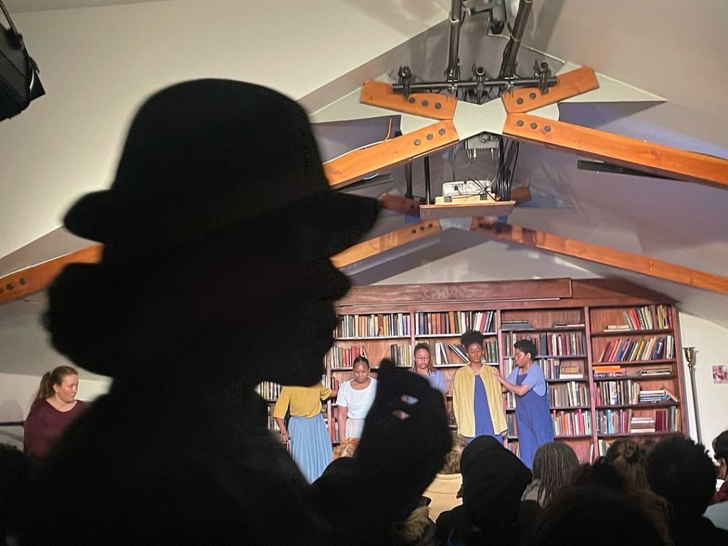 A chilling snapshot from a work-in-process performance of axes, herbs, and satchels. This scene encapsulates the suppression of midwifery via a systemic adoption of medicinal misogynoir masked as regulation.